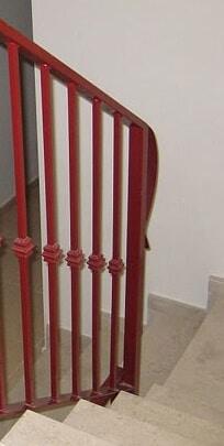 Ringhiera di ferro su scale dipinta di rosso