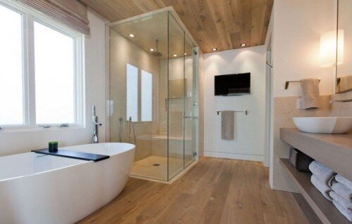 Bagno moderno con pavimentazione in legno con doccia con pareti trasparenti