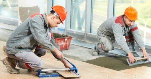 Operai che effettuano pavimentazione su ristrutturazione casa