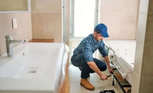 Un idraulico mentre esegue i lavori di ristrutturazione di un bagno.