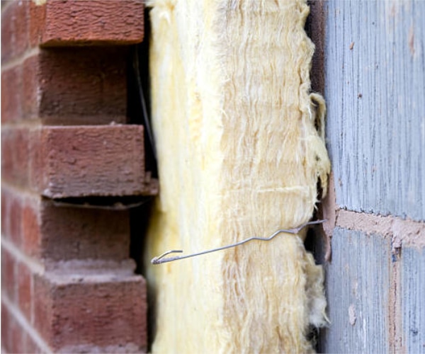 Immagine di isolamento termico della parete di una casa tramite insufflaggio con un materiale atto a ottimizzare la durata.