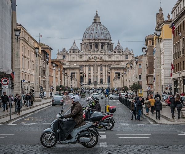 Immagine del viale che conduce a San Pietro a Roma trafficato di motorini e persone. Una situazione a rischio in vista del Giubileo 2025.