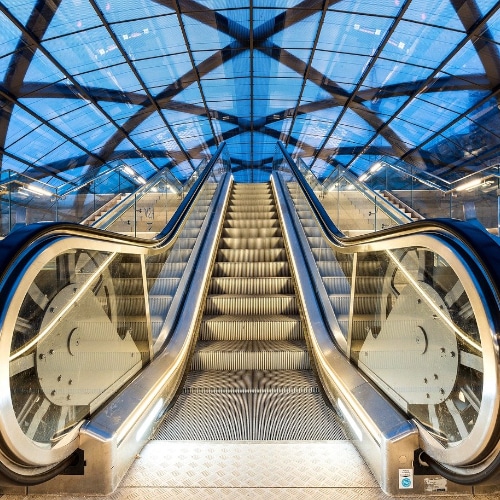 Immagine di una scala mobile installata in un contesto pubblico, una stazione o un aeroporto con cupola di vetro