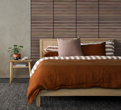 Camera da letto moderna con pannelli acustici in legno dietro il letto, ideali per ridurre il riverbero e migliorare il comfort abitativo.