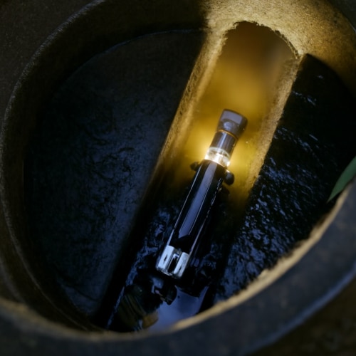 Immagine di un robot per videoispezione all’interno di un pozzetto in cemento. La telecamera illumina il condotto con acqua residua, evidenziando lo stato delle superfici. Foto di copertina per articolo Edilnet sulla videoispezione di fognature e tubazioni, utile per diagnosi, manutenzione e prevenzione guasti.