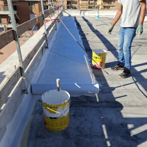 Operatore durante l’applicazione di impermeabilizzazione liquida su lastrico solare