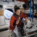 Astronauta donna ripara il bagno spaziale della capsula Orion durante la missione Artemis II verso la Luna.