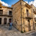 Donna davanti a una casa di 17 stanze in Sicilia acquistata dopo aver visto un video su TikTok.