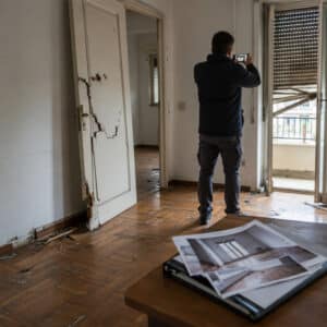 Casa devastata dopo lo sfratto con parquet e porte danneggiati.
