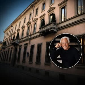 Facciata di Palazzo Orsini a Milano, ripresa in prospettiva dal basso, con un medaglione circolare in basso a destra che mostra Giorgio Armani, sorridente, seduto su una scala.